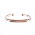 Macro detail of rose gold stainless steel open bangle with coil design and smooth ball ends - Rose Gold