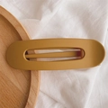 Close-up of a large ginger matte finish hair clip on a wooden tray with white cloth - Matte Ginger Yellow