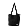 Close-up of black corduroy tote bag featuring a high-quality zipper and woven brand label - Black