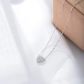 Dettaglio del ciondolo a cuore in argento S925 con pavé di zirconi su morbido tessuto bianco - Argento