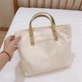 Close-up of durable canvas tote with reinforced leather handles and bronze rivets - Milky White