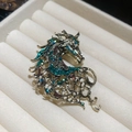 Détail de la broche tête de cheval avec strass colorés sur métal doré vintage - Or-Vert