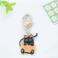 Dettaglio portachiavi smaltato gatto nero con chiusura a cuore dorata e design a zucca - Gatto Nero in Zucca
