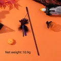 Gioco per gatti a tema Halloween con ragno di peluche, piume e nastri su sfondo arancione - Giocattolo di Halloween Ragno Nero