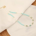 Nahaufnahme der Boho-Perlenkette mit Türkissteinen und goldenem Karabinerverschluss - Lichtdurchlässiges Grün