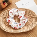 Close-up of fabric Christmas scrunchie with deer and star patterns in a woven basket - Basic Style / Christmas White Snowflake