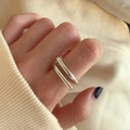 Nahaufnahme eines silbernen mehrlagigen Wellenrings an der Hand mit weichem Licht - Doppellagiger Minimalistischer Offener Stil (J608)