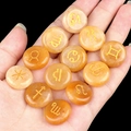 Set of 12 orange zodiac crystal stones with gold engraved signs held in hand - Yellow Stone (12 Pcs)