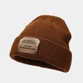 Close-up detail of the brown knit beanie featuring rib-knit texture and fabric patch logo - Coffee