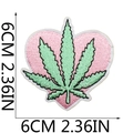 Détail macro d'un écusson cœur rose de 6cm avec broderie verte et coutures denses - No. 9 Cœur Feuille Sativa (XT316)