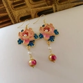 Primer plano de pendientes de flores esmaltadas rosas con perlas y detalles dorados - Estilo de Gancho / Rosa