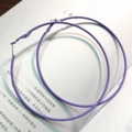 Boucles d'oreilles créoles violettes mates avec finition gommée posées sur un livre - Peinture Caoutchouc Violet