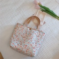 Vista dettagliata della borsa floreale trapuntata con bottone a pressione in bronzo - Fiori Bianchi Rossi