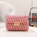 Crossbody houndstooth bag in red and beige with a gold chain strap on a white table - Red