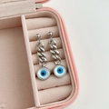 Detalle de pendientes de ojo de demonio con cadena cubana en una caja de regalo rosa - Color Acero (DEG484)