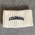 Detail eines weiß gestrickten Stirnbands mit schwarzer Colorado-Stickerei für den Winter - Beige
