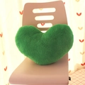 Green plush heart-shaped pillow displayed on a pink chair for cozy home decor - Dark Green Heart