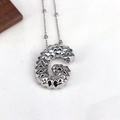 Macro shot of silver letter G pendant with luxury geometric texture on white fabric - Letter G