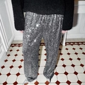 Detail of silver sequin wide leg trousers paired with high heels for a festive party look - Gray