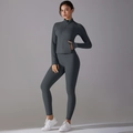 Detail of dark gray yoga set featuring zip-up jacket with thumbholes and high-waist leggings - Graphite Grey