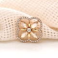 Detailed macro view of a gold clover charm with clear crystals and sparkling rhinestones - Champagne