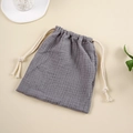 Detail view of dark grey cotton muslin storage bag with textured fabric and cream drawstring - Dark Gray