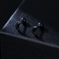 Minimalistische schwarze Halbmond-Ohrstecker mit Schraubverschluss auf Schmuckschachtel - Schwarz (Einzelstück)