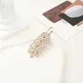 Vue détaillée de la pince à cheveux feuille dorée avec strass et texture ajourée - Feuille