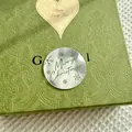 Macro shot of silver Merry Christmas metal cupcake topper on vintage green embossed gift box - Merry Christmas Silver Style
