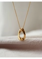 Dettaglio macro del ciondolo ad anello dorato su tessuto morbido gioielli minimal - Oro