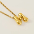 Golden balloon style letter M pendant necklace with a polished finish and curb chain - Letter M
