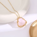 Macro detail of Buddha pendant necklace with pink resin and gold zircon framing - Pink Buddha