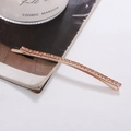 Dettaglio di un fermaglio per capelli in oro rosa con file di strass lucenti su rivista - Base Oro Rosa Strass Champagne