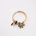 Gouden kabelarmband met vlinder- en bladhangers in een minimalistische setting - Zwart