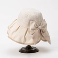 Dettaglio di un cappello da sole beige a tesa larga con fiocco su supporto in metallo - M(56-58cm) / Bianco Sporco