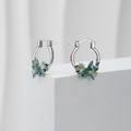 Macro view of silver hoop earrings featuring blue dragonfly and daisy enamel charms - Silver 【Dragonfly Flower】