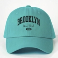 Close-up of turquoise cotton baseball cap featuring Brooklyn New York 1898 vintage print - Lake Blue