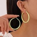 Minimalist light green geometric hoop earrings for women shown worn on a fashion model - Green Large Hoop