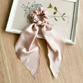 Detail of pink silk satin scrunchie with long ribbon bow on wooden background - Champagne