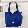 Front detail of large canvas tote bag in navy blue with a functional outer pocket - Klein Blue