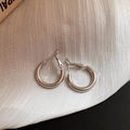 Macro shot of minimalist silver hoop earrings on elegant white draped fabric backdrop - 20mm Silver Smooth Round Hoop Style (100#)