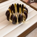 Detail view of rhombic brown matte and gold metal segments on stretch bracelet - Curved Wave Style / Coffee