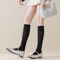 Retro black knee-high socks with white polka dots paired with Mary Jane shoes - Black