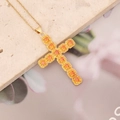 Dettaglio del ciondolo a croce dorata con zirconi arancioni su pietra beige - 3# Giallo Arancio