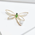 Détail macro d'une broche libellule dorée avec cristal et perle décorative - Libellule en Cristal Vert