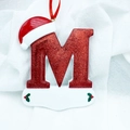 Christmas letter M ornament with red glitter finish, Santa hat, and hanging silk ribbon - Letter M