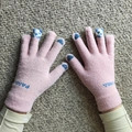 Close-up of pink knit gloves with blue panda motifs and heart designs on fingertips - Panda Pink