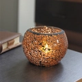 Amber mosaic glass candle holder with warm candle light on a dark wooden table - Intense Coffee