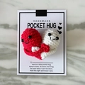 Handmade red and white crocheted heart pocket hug on a gift card for a warm embrace - Red and Off-White