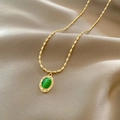 Vintage-Goldperlenkette mit ovalem grünem Opal-Anhänger auf Champagner-Satin-Stoff - Grün